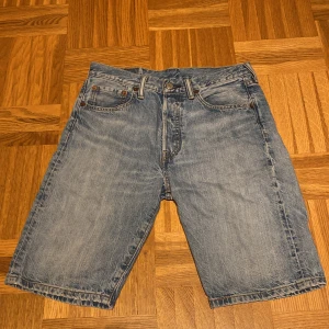 Levi's 501 jeansshorts - Säljer ett par klassiska Levi's 501 jeansshorts i ljusblå denim. Modellen har knappgylf Perfekt avslappnad passform och vintagekänsla. Har ingen defekt och är knappt använda. 