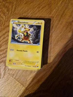 Gula pokémon kort - Samlar du på Pokémonkort? Här är Electabuzz, en ikonisk el-Pokémon med coolt motiv och attacken Knuckle Punch. Perfekt för dig som vill utöka din samling eller spela med vänner. Kortet är i fint skick och redo för nya äventyr!