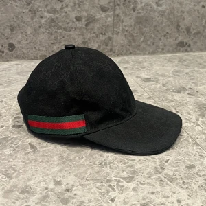 Gucci Canvas Keps - Hej, säljer nu min Gucci keps då den inte kommer till använding. Kepsen är i storlek M och passar alla möjliga outfits. Skriv vid minsta lilla fundering!