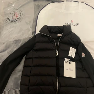 Svart pufferjacka från Moncler - Svart  från Moncler med quiltad front och släta, stickade, storlek S men storleken är liten i med kan passa s men även Xs