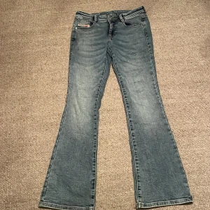 Blå bootcut jeans från Diesel, 12Y - Snygga blå jeans från Diesel med bootcut passform och klassisk femficksdesign. Jeansen har ljus tvätt och coola detaljer som Diesel Industry-märke på fickan och bak. Tillverkade i slitstarkt denim-material, perfekta för dig som gillar en avslappnad stil. Frakt tillkommer!