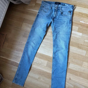 Ljusblåa replay anbass jeans - Tja! Jag säljer dessa snygga ljusblåa replay anbass jeans i storlek 30/34. Jeansen är i modellen slim fit och har lite små slitningar. Skicket är 9/10, och de har inga defekter eller skador. Hör av dig vid frågor eller om du är intresserad!