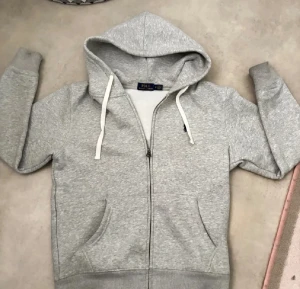Grå hoodie från Polo Ralph Lauren - Snygg grå hoodie från Polo Ralph lauren tröjan är i nytt skick 9/10 använd 2 gånger.pris går att diskutera vid minsta fundering hör av dig 👍✅