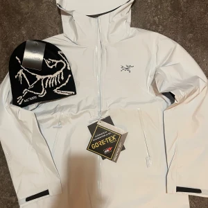 Arcteryx jacka i vit med mössa paket - Arcteryx jacka, köp jackan och mössan medföljer! Finns i M och S, nypris 5500 perfekt för vardaglig användning eller skidbacken!
