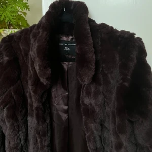 Mörkbrun pälsjacka Dorothy Perkins - Säljer en fluffig och lyxig mörkbrun pälsjacka från Dorothy Perkins. Jackan har en klassisk krage, helfodrad insida och långa ärmar. Superfint skick.
