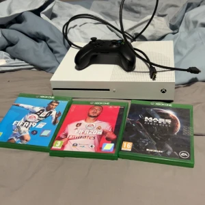 Xbox One S med spel - Xbox One S i gott skick, med tre spel: FIFA 19, FIFA 20 och Mass Effect Andromeda. Konsolen är ren och fungerar bra. Medföljer en svart handkontroll med tydlig skada på sidan, men fungerar. HDMI-kabel ingår.