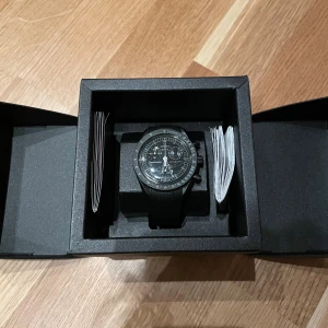 Omega x Swatch Speedmaster MoonSwatch - Säljer en Omega x Swatch MoonSwatch mission to the moon. Klockan är helt ny med plasten kvar på (därför se glaset ut som de gör på bilden) och har ett svart gummiarband på. Klockan är tidigare köpt här på Plick men har ej kommit till användning.