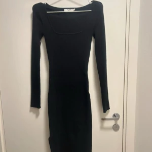 Stickad långklänning - Stickad svart långklänning med slits köpt på NA-KD. Klänningen är endast använd en gång och och därav i nyskick!