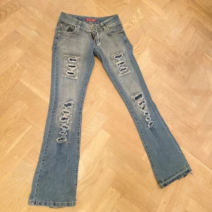 Lågmidjade blå slitna jeans - Coola jeans med slitningar