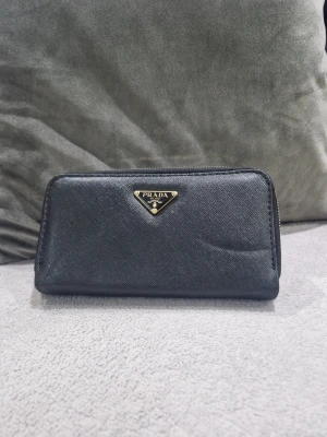 Svart plånbok  - Snygg svart plånbok. Perfekt storlek för att få plats med kort och cash.