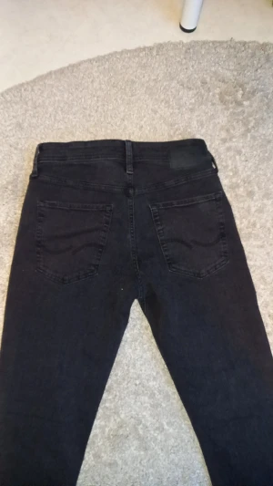 Svarta slim jeans Jack & Jones - Säljer ett par svarta jeans från Jack & Jones, modell Slim/Glenn. Jeansen har fem fickor, bälteshällor och klassisk knapp- och dragkedjestängning. Passformen är slim och materialet är jeans med en mörk ton. Perfekt för dig som gillar stilrena och smala jeans. Köpta för 1199 i butik, dem är hellt nya. pris kan diskuteras vid snabb affär🤗