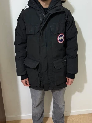 Canada Goose Expedition Parka Black jacka - Äkta! Svart parkajacka från Canada Goose med klassisk patch på bröstet, stor huva med äkta päls och flera praktiska fickor. Äkta!