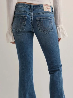 True religion joey - Säljer mina true religion/Nelly jeans! Jätte lågmidjade jeans i strechigt material med rosa detaljer på fickorna. Slitningar längst ner då jag är 165 och dem dragits i marken. Kan skicka bättre bild på defekterna och priset kan diskuteras💗