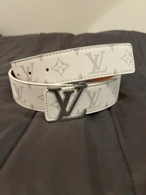 Exklusivt vit bälte  - Ett väldigt fint bälte med silver format. Storlek 115 cm