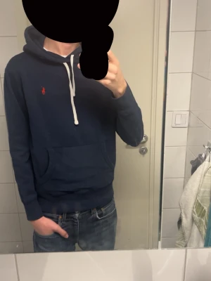 Ralph Laurent hoodie  - Säljer nu min stilrena raffe hoodie eftersom den blivit för liten. Hoodien är marinblå och är i väldigt bra skick, för att varit använd någon månad. Den har 2 sminkmärken på framsidan och ett på baksidan, dem är knappt märkbara och kanske kan  försvinna i tvätten med lite medel. Hör av dig vid frågor eller fler bilder! Priset är diskuterbart!