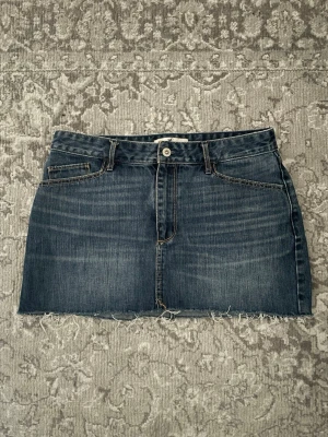 Mörkblå jeanskjol från Hollister - Säljer en trendig mörkblå jeanskjol från Hollister. Kjolen har en snygg rå kant nedtill och är tillverkad i denim med snygga slitningar. Passar perfekt till sommaren och har normal passform. Inga defekter tillkommer och jag har använt kjolen en gång endast! Dm för mått eller frågor💘
