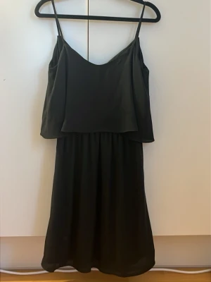Svart ärmlös kortklänning - Snygg svart klänning med smala axelband och v-ringad hals. Jättebra skick! Stl 38 men passar mig som är S