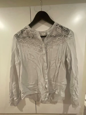 Ljus grå blus från rosemunde st.36 - En super fin blus med spets framtill och knappar, st.36 från rosemunde copenhagen. 