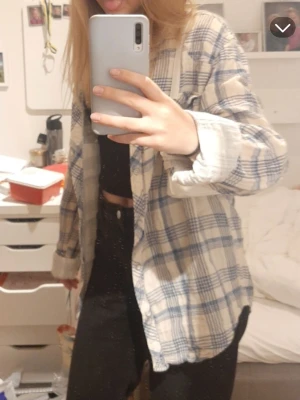 Blårutig oversize skjorta  - Säljer en chill blårutig skjorta från SUB i storlek Large. Skjortan är gjord i mjukt linne och har klassisk krage, långa ärmar och knappar framtill. Perfekt att slänga över en t-shirt för en avslappnad look. Två bröstfickor med knappstängning.