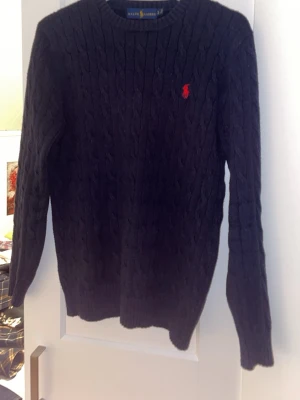 Stickad Ralph Lauren tröja - Mörkblå stickad Ralph Lauren tröja i bra skick, den har inga hål eller slitningar