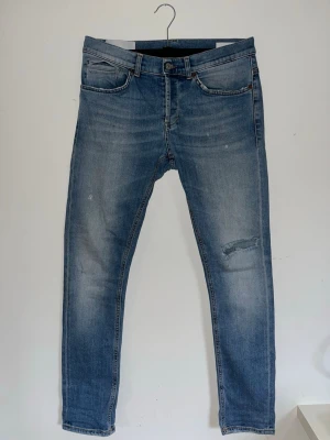 Dondup jeans blå - Säljer ett par riktigt schyssta Dondup jeans i färgen blå, med lite klassiska slitningar som gör jeansen riktigt stil rena.