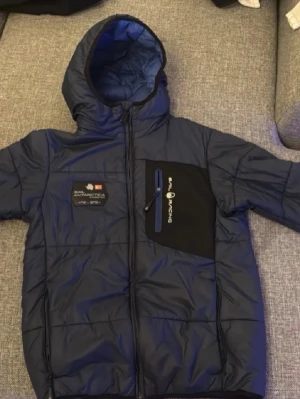 Blå Sail Racing pufferjacka till riktigt bra pris! - Säljer nu denna riktigt varma och sköna vinterjacka från premiummärket sail racing för ett riktigt bra pris just eftersom att jag har växt ur den:) Storlek: Junior 140. Gratis frakt!
