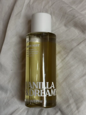 Vanilla & Dreamy Body Mist - Body mist med fluffig vanilj, gyllene karamell och coconut cloud, berikad med essentiella oljor. Volym: 250 ml. Perfekt för dig som vill ha en söt och fräsch touch i din vardag.