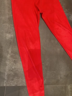 Röda fleecebyxor Polarn O. Pyret - Snygga röda fleecebyxor från Polarn O. Pyret, storlek 146/152. Mjuka och sköna med resår i midjan och diskret logga på benet. Perfekta för chill eller när du vill vara extra bekväm. Passar dig som gillar färg och vill ha något riktigt gosigt.