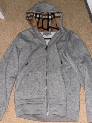 Burberry hoodie - En fin burberry hoodie i nyskick. Sparsamt använd har inga defekter eller något liknande. Pris går såklart att diskutera. Tveka ej att skriva om du har funderingar.