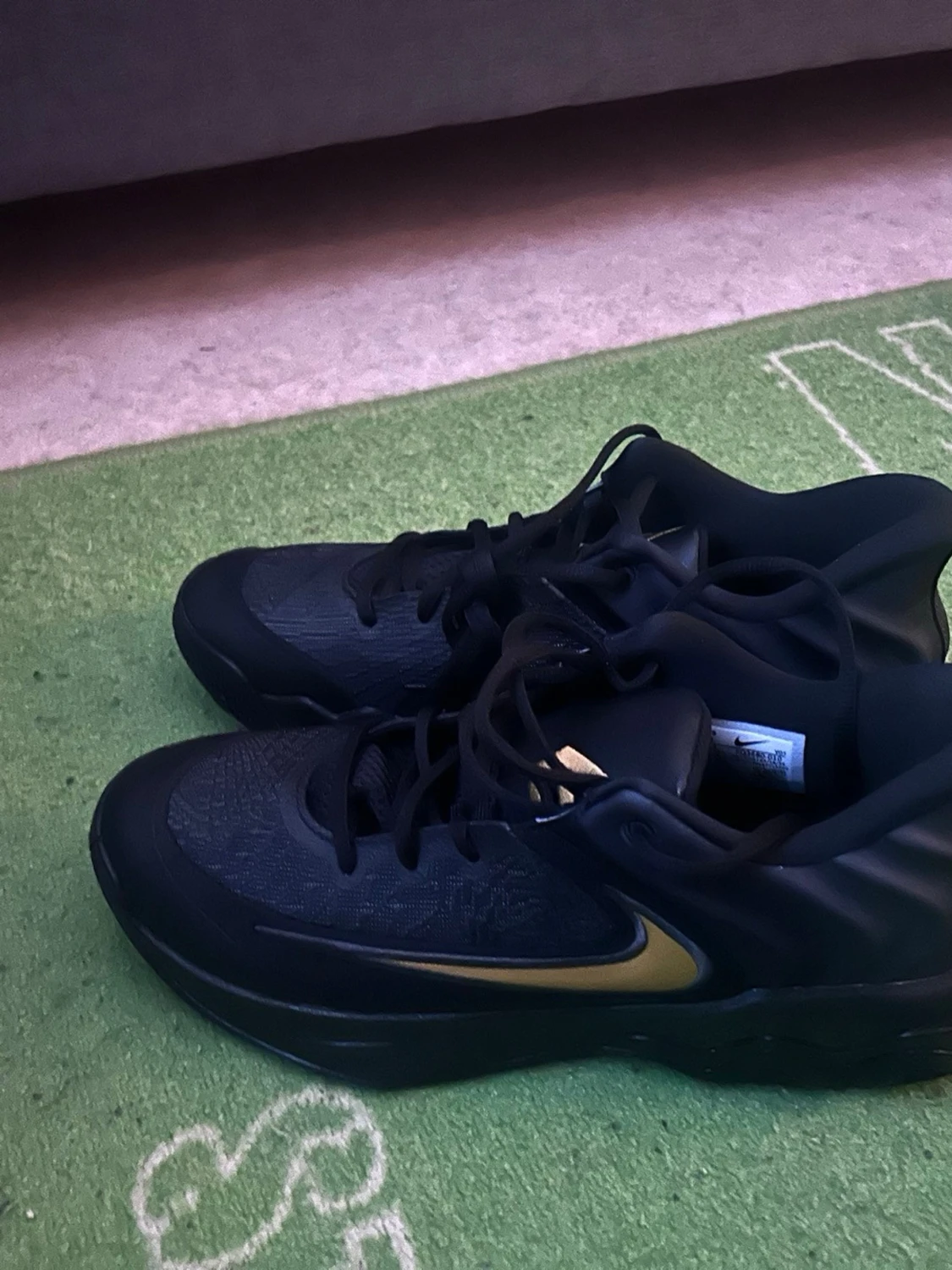 Svarta Nike sneakers med gulddetaljer