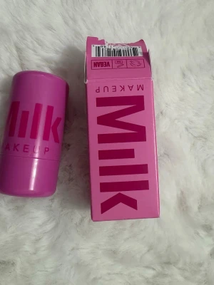 Milk Makeup Burst Rouge Stick - Säljer en Milk Makeup rouge stick i färgen Burst. Kommer i en snygg rosa förpackning och är vegansk. Perfekt för att ge kinderna en fräsch och pigg färg med krämig formula som är lätt att blenda ut.