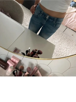 Blåa jeans  - Säljer ett par blå bootcut jeans💕 med snygg tvätt och slitningar. Jeansen har låg midja, klassiska fickor fram och knappar💘 på bakfickorna. Supersnygga, säljer dessa eftersom de är lite för korta för mig❣️