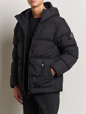 Svart pufferjacka från Stone Island - Säljer en svart pufferjacka från Stone Island med huva och dragkedja framtill. Jackan har ett klassiskt märke på ärmen och stora fickor med knappstängning. Perfekt för dig som vill ha en stilren och varm jacka med streetkänsla.