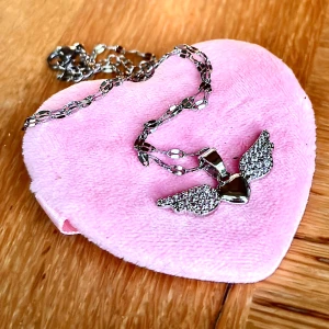 Fint halsband med hjärta och vingar! - Fint halsband i rostfritt stål med hjärta och vingar. Kedja medföljer. Mått hänge: 3 x 1,2 cm. Kedja: 50 cm. Nytt!