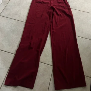 Kostymbyxor  - Vinröda kostymbyxor från bikbok, stl xs. Passar mig i längden som är 168 cm, de har blivit noppriga💗