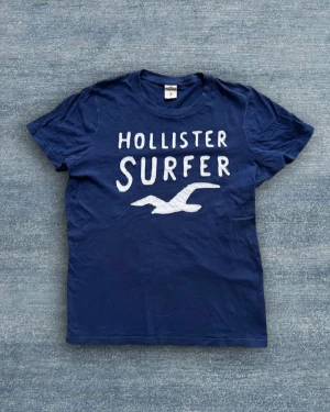 Blå Hollister Surfer t-shirt - Marinblå T-shirt från Hollister i mycket bra skick!