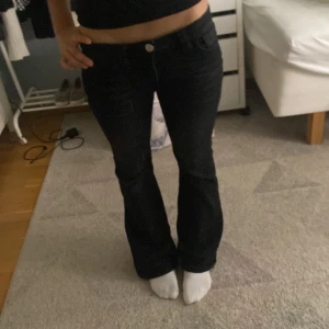 Svarta lågmidjade bootcut jeans med pärldetaljer  - Snygga svarta jeans med bootcut passform och låg midja. Baktill har fickorna coola pärldetaljer som ger extra edge. Jeansen kommer från gina tricot och säljs då de inte kommer till användning längre, är i jättefint skick.