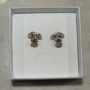 Petite Timo earrings Caroline Svedbom - Säljer ett par superfina örhängen från Caroline Svedbom! Dom heter Petite Timo earrings i Crystal och är aldrig använda.  Örhängena är i guld och är i clips, speciellt bra om man är nickelallergiker. Dem är väldigt lyxiga och eleganta, passar både vardag och fest! 💛