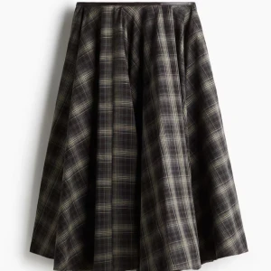 Ny CIRKELSKUREN BOMULLSKJOL från H&M - Ny med tags. En enkellång, cirkelskuren kjol i vävd bomull med ytbehandlat kantband i midjan. Kjolen har lös passform, diskreta sidfickor samt dold dragkedja med hyska och hake i ena sidan. Beskrivning:  Mörkgrå, Rutig Storlek: Baksida: Längd: 74.0 cm (Storlek 38) Midja: Omkrets: 77.0 cm (Storlek 38) Kollektion: A/W 2025