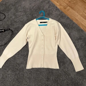 Beige kofta från Vero Moda - Snygg beige kofta från Vero Moda i storlek S. Kan även passa XS. Köpt för 499! Endast använd 2 ggr och är som ny!