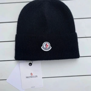  Moncler mössa - Supersnygg och varm Moncler-mössa i svart, klassisk modell med den ikoniska loggan framtill. Aldrig använd, Kommer med originalpåse och taggar (inklusive QR-kod för äkthetskontroll).     Perfekt till vintern – passar både damer och herrar. Nypris 499kr. Skick: Nyskick 🎨 Färg: Svart 📍 Storlek: One size  Fraktas snabbt och noggrant paketerad 💌