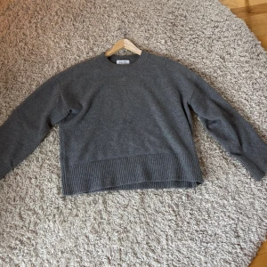Grå stickad tröja från & Other Stories - Mysig grå stickad tröja från & Other Stories med rund hals och bred ribbad kant nedtill och vid ärmslut. Den är sparsamt använd och säljer den för 240kr!💗