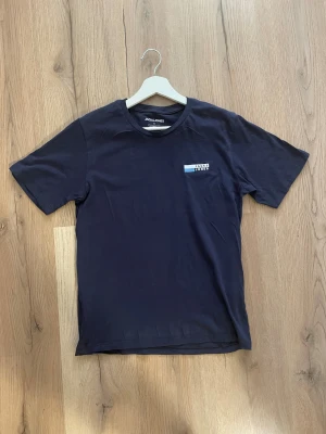 En snygg mörkblå T-Shirt från Jack&Jones🤝 - ✨ Jack & Jones mörkblå T-shirt – stilren & superfräsch! Ett perfekt vardagsplagg som alltid funkar. Sitter snyggt och är i fint skick 👌  📐 Mått: • Axelbredd: 42 cm • Längd: 65 cm  💸 Pris: 119 kr 🚀 Först till kvarn – skicka DM om du vill köpa!
