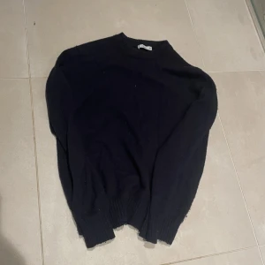 Marin blå stickad tröja med rund hals från ming - En enkel marin blå stickad tröja med rund hals och långa ärmar. Perfekt för dig som gillar en clean och klassisk look. Ribbstickade muddar vid ärmslut och nederkant ger en snygg finish. Passar till jeans eller cargo pants.