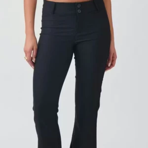 Svarta bootcut byxor med fickor - Snygga svarta bootcut byxor med hög midja och två bakfickor med lock och knapp. Byxorna har en klassisk siluett med utsvängda ben och stängs med två knappar fram. Materialet är mjukt och stretchigt, perfekt för en trendig look.