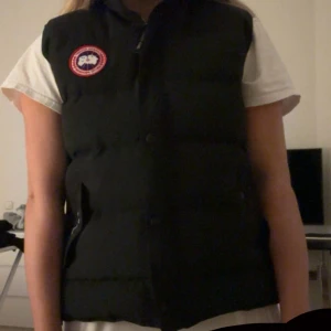 Svart Frestyle väst från Canada Goose  - Fick som present av min faster men har aldrig använt. Den är en XL men satt bra pa mig och jag är en S/M. Säljer för att jag har aldrig använt. Men den är som ny. Ingenting fel pa den. Kan skicka mer bilder om det behovs.💓