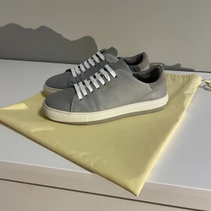 Grå sneakers från Axel Arigato - Snygga grå sneakers från Axel Arigato i bra skick. Storlek 39. Original så är det grå snören som även medföljer.
