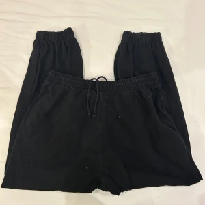 Svarta mjukisbyxor från H&M, storlek S - Svarta mjukisbyxor från H&M i storlek S. Byxorna har resår i midjan med snörning och resår vid bensluten. Tillverkade i mjukt bomullsmaterial med inslag av polyester, perfekta för chill eller träning.