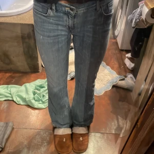 Blå bootcut jeans från Gant - Säljer ett par snygga blå jeans från Gant med klassisk bootcut-passform. Jeansen är mid waist, har fem fickor och är tillverkade i mjukt denimtyg. Deras midja har resor så man kan ställa in hur tajt man vill ha dom. Midjemått rakt över utan inspänning: 38 innebens längd: ca 68 cm