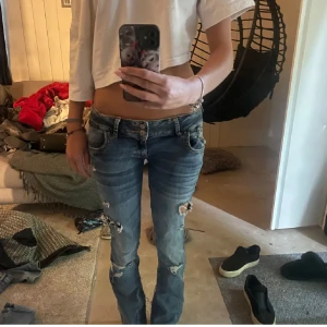 jeans från LTB - Säljer ett par blå jeans från LTB Blue Addicted med låg midja och slitna detaljer på benen. Jeansen är jättesnygga väldigt låg midja det och bootcut modell skulle jag säga men jag säljer för har för mycket jeans🥰 de är insydda lite men de är bra gjort så det är ingenting som gör dem sämre kvalitet❤️ pris kan diskuteras vid snabb affär